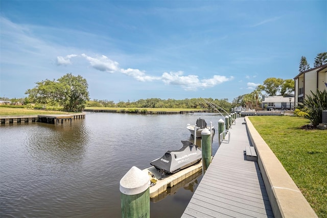 view of dock featuring a water view and a yard
