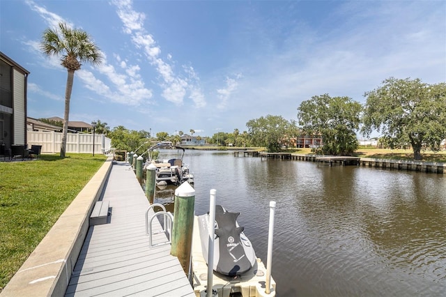 dock area featuring a water view and a lawn