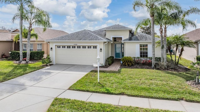 ranch-style home with a garage, concrete driveway, a front lawn, and stucco siding