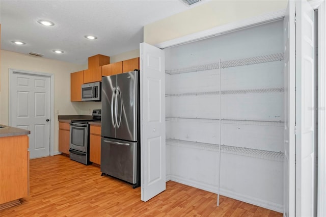 kitchen with light wood-type flooring and appliances with stainless steel finishes