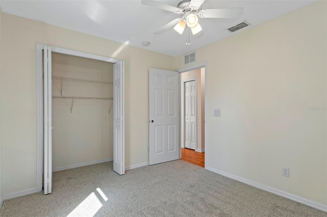 unfurnished bedroom with a closet, ceiling fan, and light colored carpet