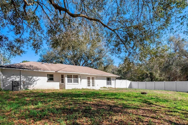 rear view of house featuring french doors and a yard