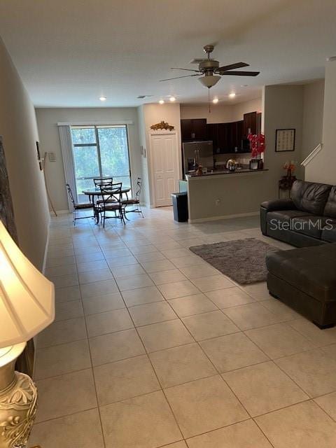 living room featuring light tile patterned floors and ceiling fan