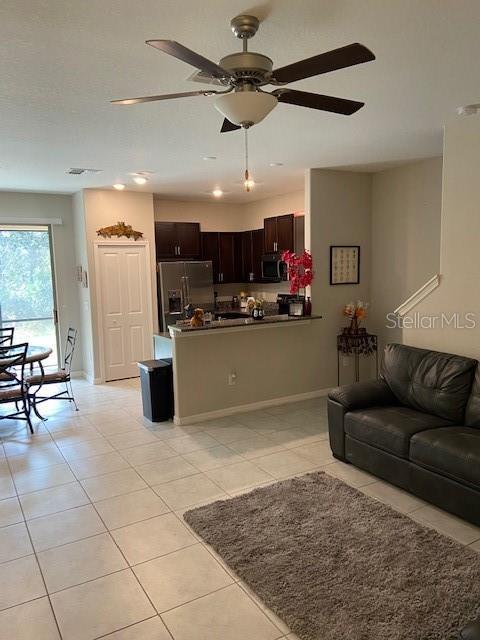 living room with ceiling fan and light tile patterned floors