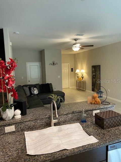 kitchen featuring stainless steel dishwasher, sink, light tile patterned floors, and ceiling fan