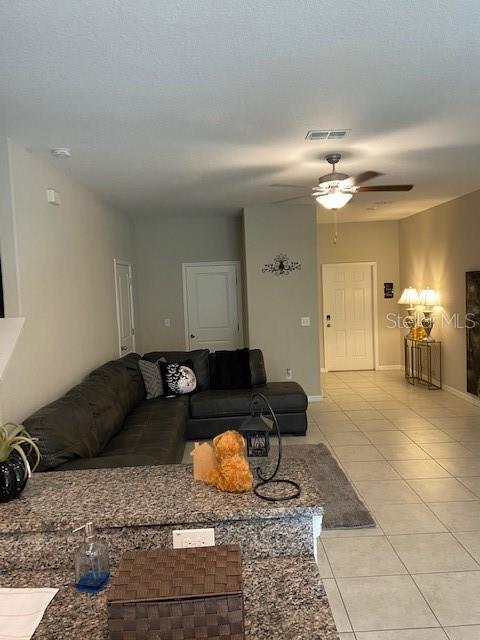 tiled living room with ceiling fan