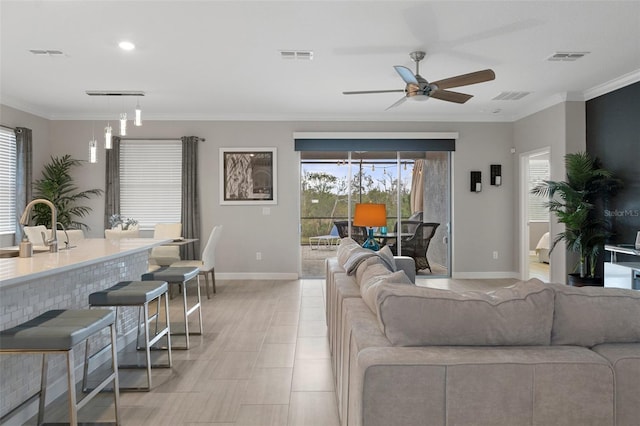 living area featuring visible vents, plenty of natural light, and crown molding