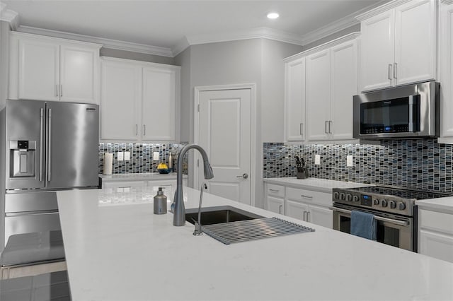 kitchen featuring recessed lighting, decorative backsplash, white cabinets, appliances with stainless steel finishes, and crown molding