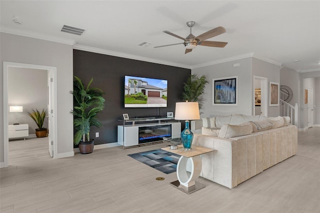 living room with visible vents, wood finish floors, baseboards, ornamental molding, and a ceiling fan