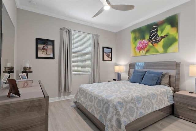 bedroom with a ceiling fan, baseboards, light wood-type flooring, and ornamental molding