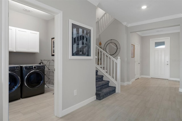 washroom featuring baseboards, ornamental molding, and washing machine and clothes dryer