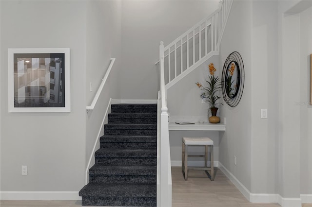 stairway with baseboards and wood finished floors