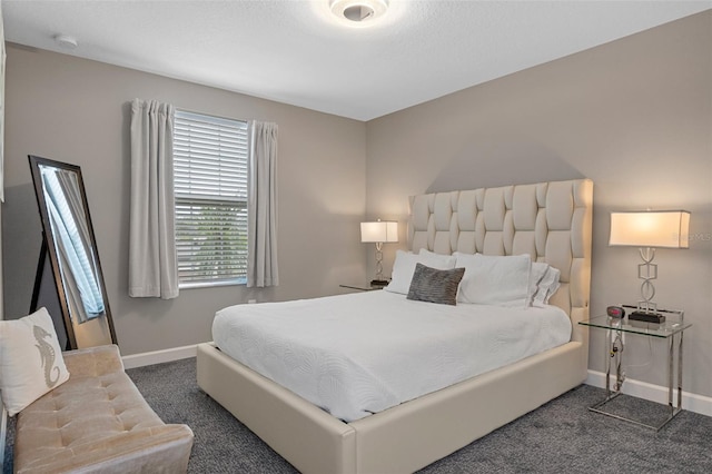 bedroom featuring baseboards and dark colored carpet