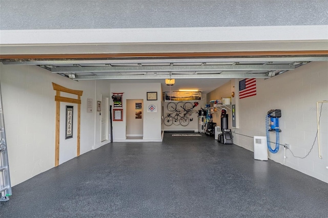 garage featuring concrete block wall and a garage door opener