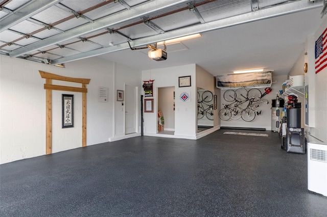 garage with water heater, concrete block wall, and a garage door opener