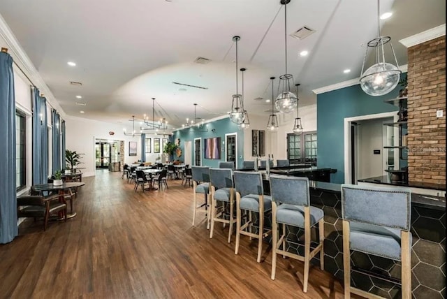 kitchen featuring visible vents, dark wood-type flooring, pendant lighting, and ornamental molding