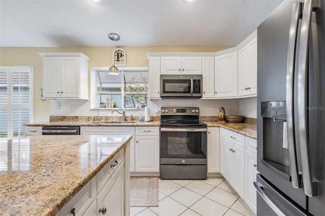 kitchen featuring light tile patterned flooring, white cabinetry, sink, hanging light fixtures, and stainless steel appliances