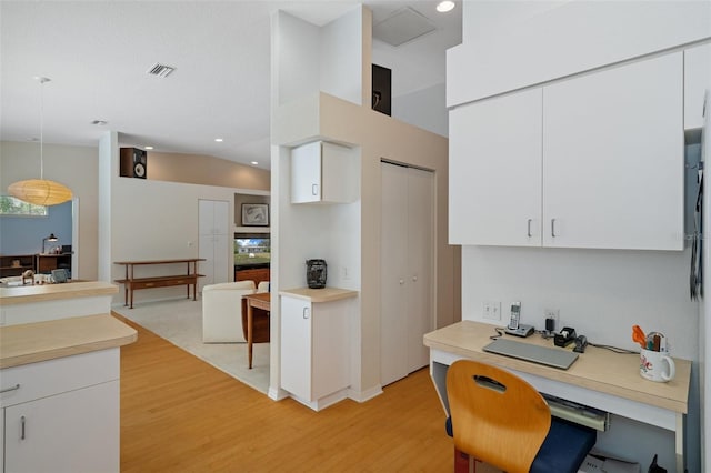 kitchen featuring visible vents, white cabinets, light countertops, and decorative light fixtures