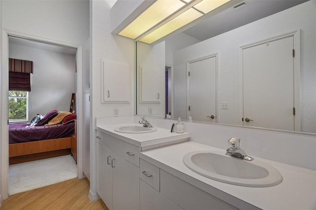 bathroom featuring vanity, wood finished floors, connected bathroom, and visible vents