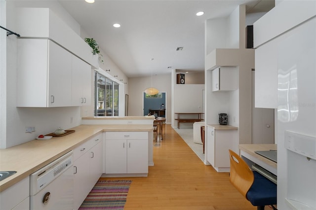 kitchen featuring light wood finished floors, light countertops, hanging light fixtures, white cabinetry, and white dishwasher