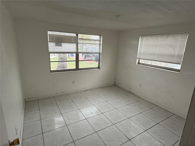 unfurnished room with a textured ceiling