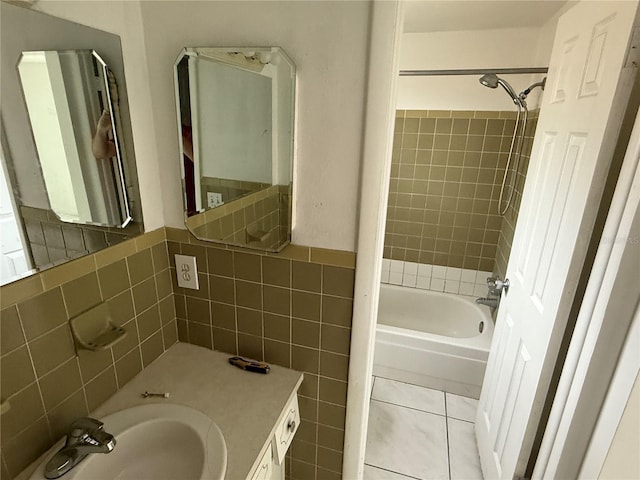 bathroom featuring tile patterned flooring, vanity, tile walls, and tiled shower / bath