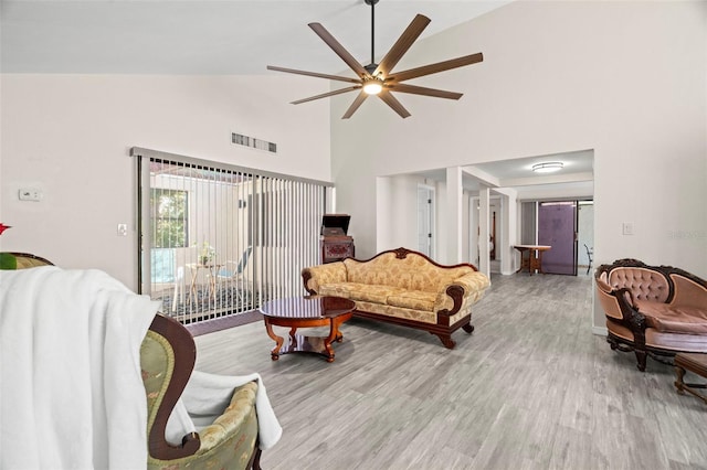 living room featuring ceiling fan, high vaulted ceiling, and light wood-type flooring