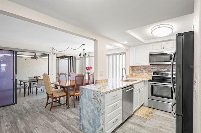 kitchen featuring sink, light hardwood / wood-style flooring, white cabinets, and appliances with stainless steel finishes