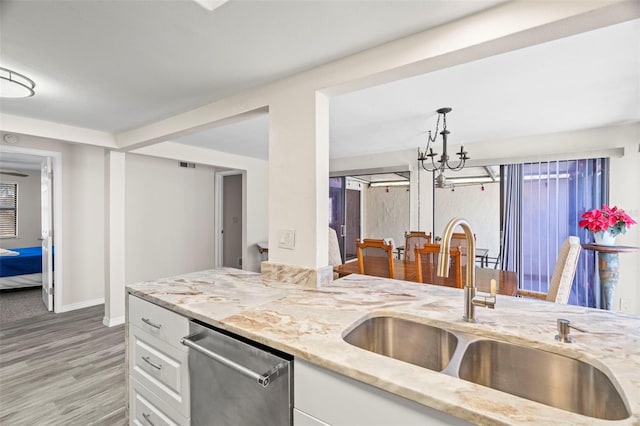 kitchen with white cabinetry, sink, light stone counters, and dishwasher