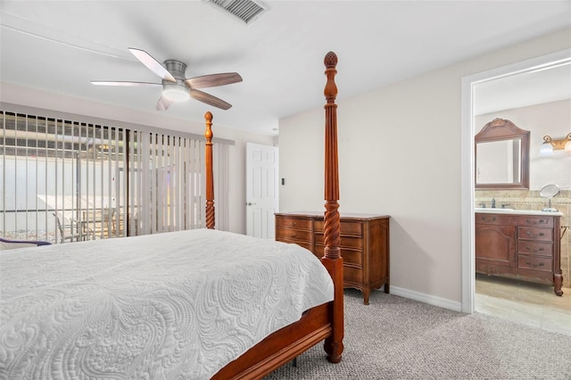 bedroom with sink, ensuite bath, light colored carpet, and ceiling fan