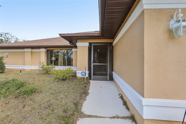 entrance to property featuring a yard