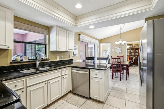 kitchen with white cabinetry, dark stone countertops, appliances with stainless steel finishes, kitchen peninsula, and pendant lighting