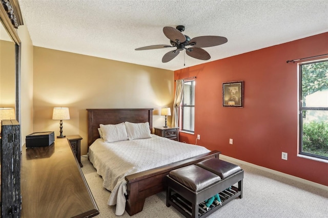 bedroom with light carpet, ceiling fan, and a textured ceiling