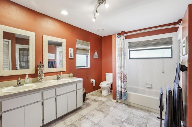 full bathroom with a healthy amount of sunlight, toilet, shower / tub combo, and vanity