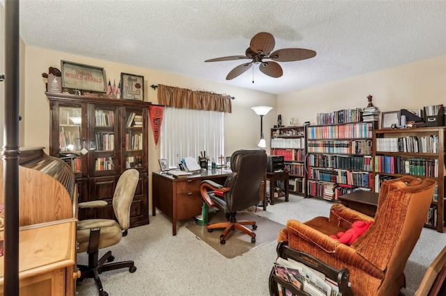 carpeted office featuring ceiling fan and a textured ceiling