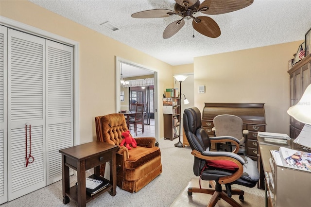 carpeted office with ceiling fan and a textured ceiling