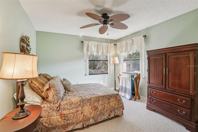 carpeted bedroom with ceiling fan and a textured ceiling