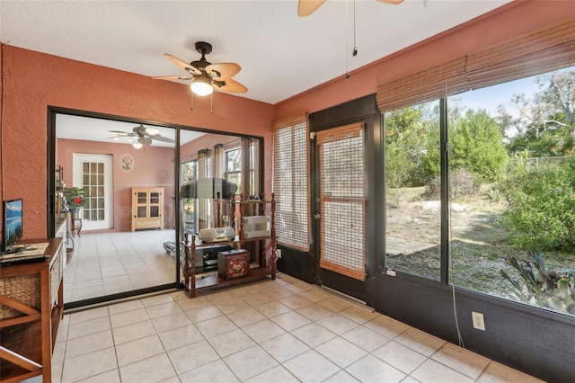 unfurnished sunroom featuring ceiling fan