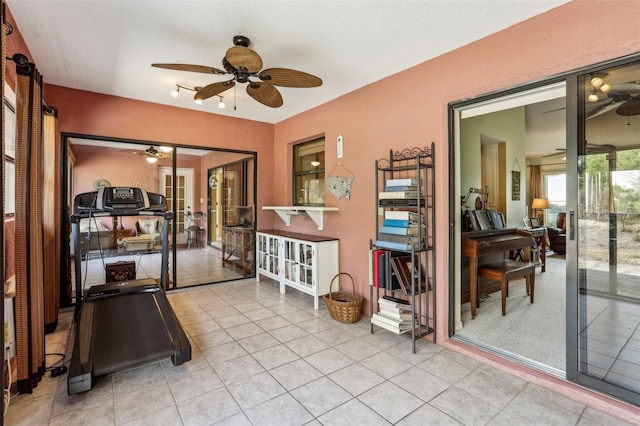 exercise room with light tile patterned floors, ceiling fan, and french doors