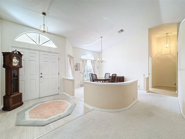 8447 Pavilion Dr, Hudson, FL 34667 - carpeted entryway featuring baseboards, a textured ceiling, visible vents, and a notable chandelier