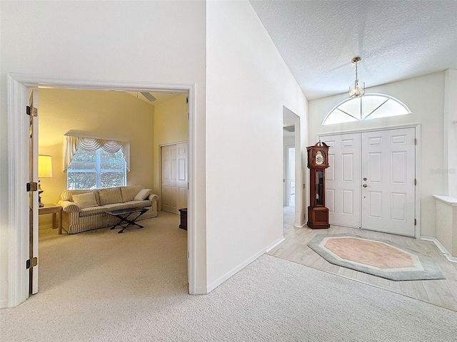 8447 Pavilion Dr, Hudson, FL 34667 - carpeted foyer featuring a textured ceiling, high vaulted ceiling, baseboards, and a healthy amount of sunlight
