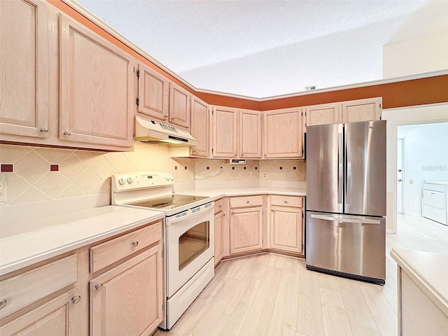 8447 Pavilion Dr, Hudson, FL 34667 - kitchen featuring light countertops, white range with electric stovetop, under cabinet range hood, freestanding refrigerator, and light brown cabinets