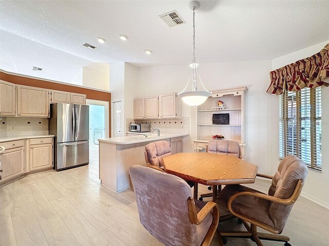 8447 Pavilion Dr, Hudson, FL 34667 - dining space featuring lofted ceiling, visible vents, and light wood-type flooring