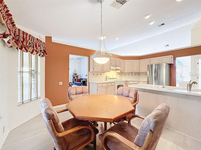 8447 Pavilion Dr, Hudson, FL 34667 - dining room featuring baseboards, visible vents, light wood-type flooring, and vaulted ceiling