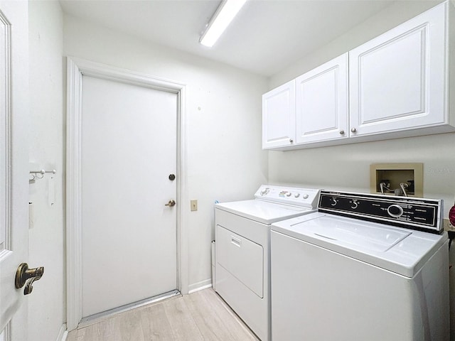 8447 Pavilion Dr, Hudson, FL 34667 - laundry room with baseboards, cabinet space, light wood-style flooring, and separate washer and dryer