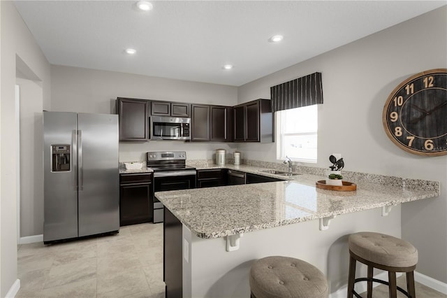 kitchen with appliances with stainless steel finishes, a kitchen bar, and kitchen peninsula