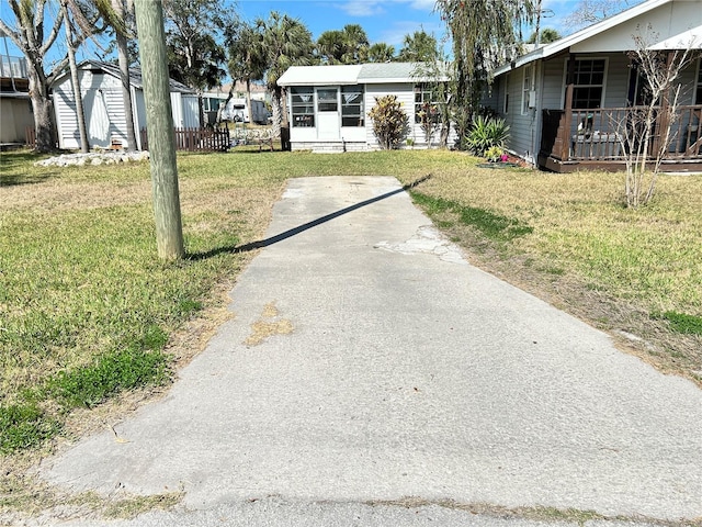 view of front of house featuring a storage shed and a front lawn