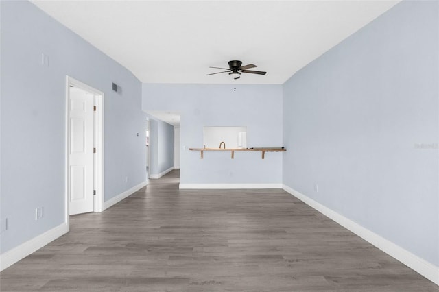 unfurnished living room featuring dark hardwood / wood-style floors and ceiling fan