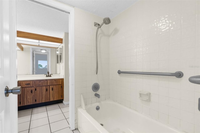 bathroom featuring tiled shower / bath, vanity, tile patterned flooring, and a textured ceiling