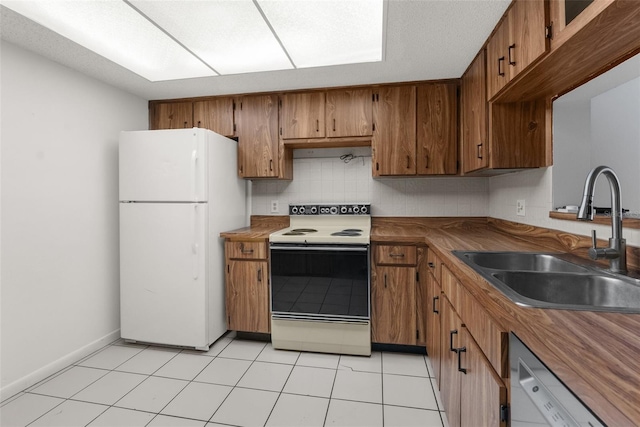 kitchen featuring tasteful backsplash, white appliances, sink, and light tile patterned floors